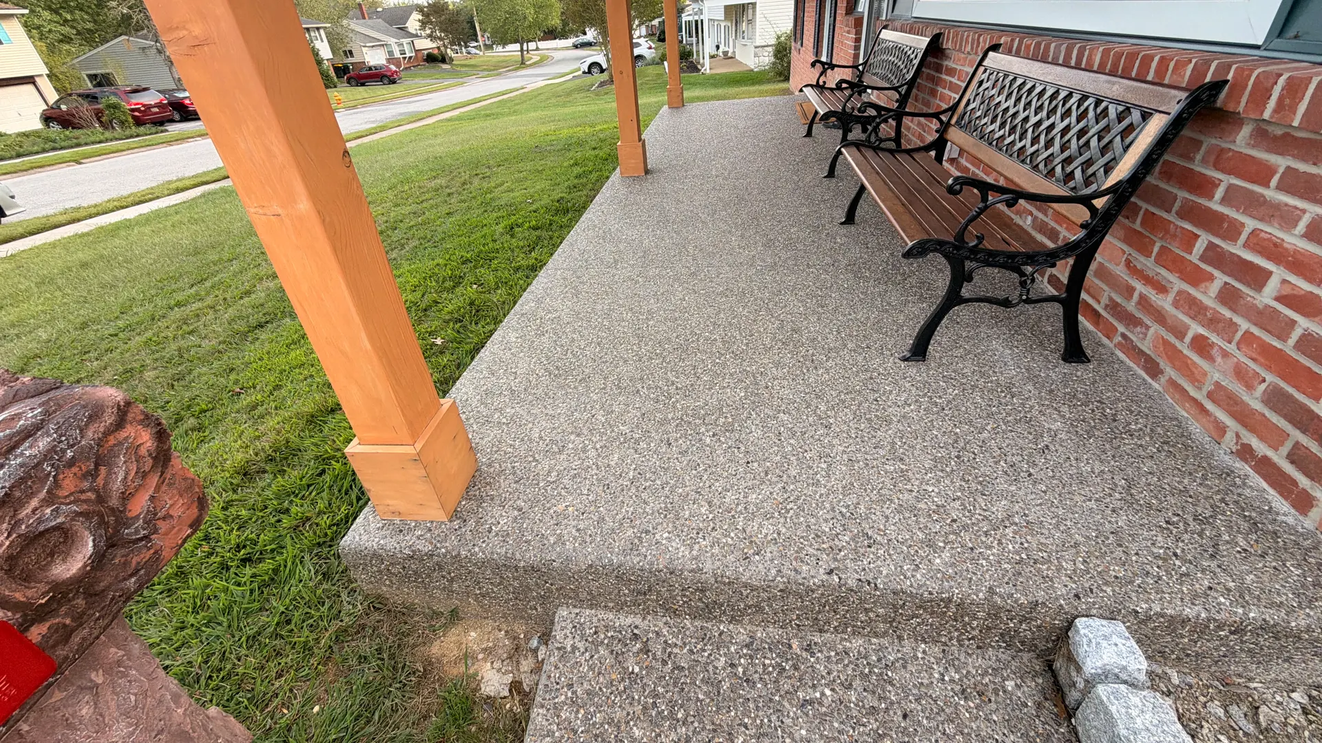 An exposed aggregate walkway beside a brick home